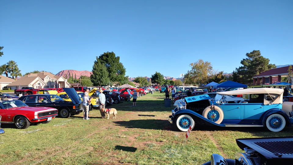 Classic cars fill a park beneath the red cliffs near St. George, Utah